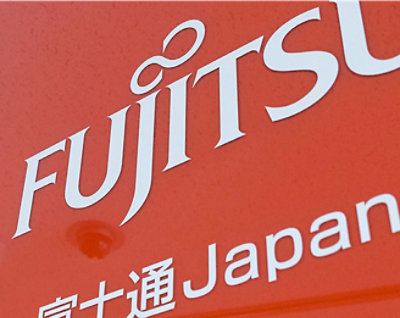 入り口近くに大きく照らされた Mercedes-Benz のロゴがあるモダンなガラス張りのオフィスビルの外観の夜景。