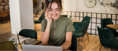 電話で話しながら微笑んでいる女性。