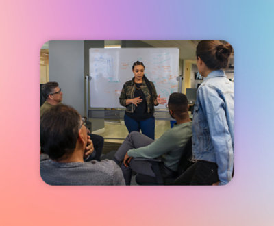 ホワイトボードの前に立って座っている男性と話している女性