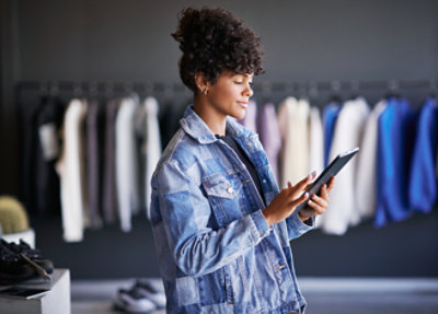A woman with curly hair holding a tablet.