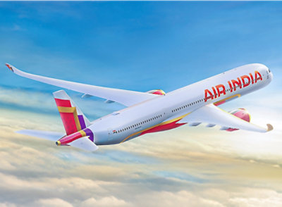 A large white Air India airplane flying in the sky.