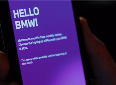 A person's hand holding a phone with a screen displaying a welcome message.
