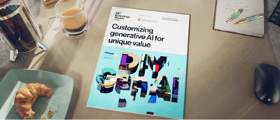 A book about DIY Gen AI rests on a table with a mouse, pen, coffee mug, and a snack beside it.