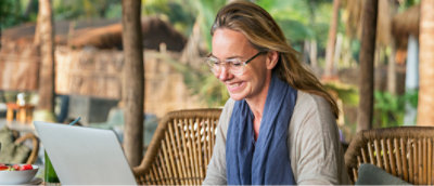 a woman smiling at a laptop