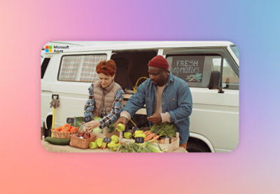 A man and woman at a fruit stand with a table of produce.