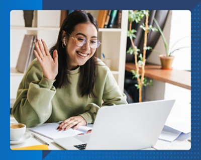 Женщина указывает на ноутбук с растением в горшке рядом.