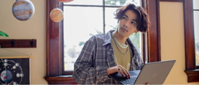 Мужчина сидит перед ноутбуком.