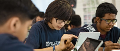 Мужчина в очках смотрит на планшет.