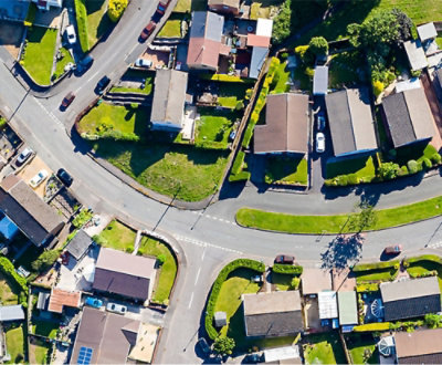 Aerial view of houses, streets, and green spaces.