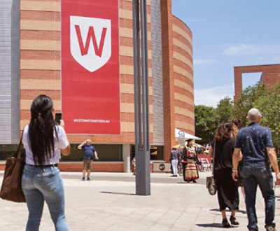 A group of people walking in front of a Western Sydney university.