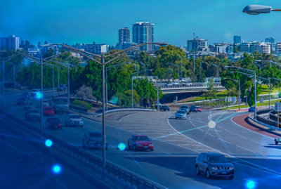 A road with cars and a city in the background.