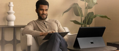 A man sitting in a chair using a tablet.