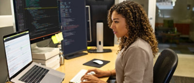 A smiling woman working on the laptop in office