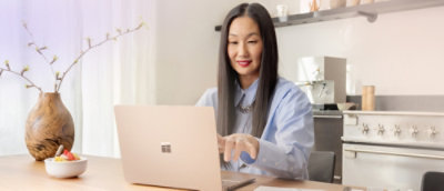 Woman working on a laptop with focused attention.