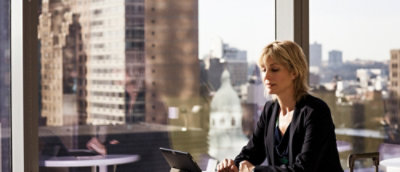 Woman smiling while using a dekstop in a room 