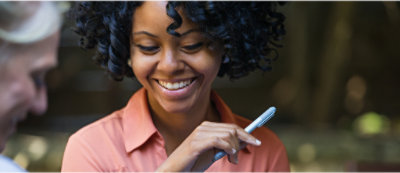 Žena se usmívá a drží pero