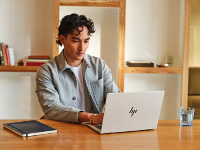  オフィス内でノート PC を使用している男性。