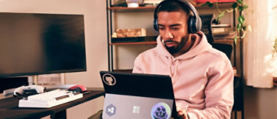A person wearing headphones and using a laptop.