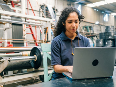 professional working on a laptop in an industrial setting.