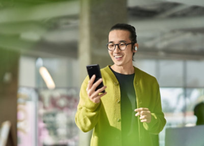 A man smiling while holding a phone.