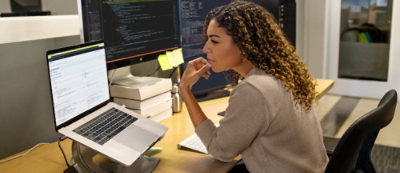 Young woman with curly hairs working on a laptop 
