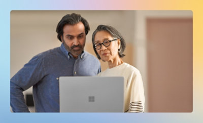 白い面の上で、ノート PC を見ている男性と女性。