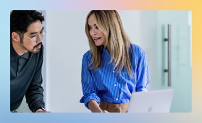 座ってノート PC を見ている男性と女性。