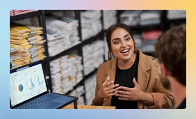 グラフを表示しているノート PC の前で話している女性と男性。