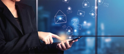 Osoba u odelu uspostavlja komunikaciju sa pametnim telefonom, usled čega se u vazduhu pojavljuje više ikona za e-poštu, 