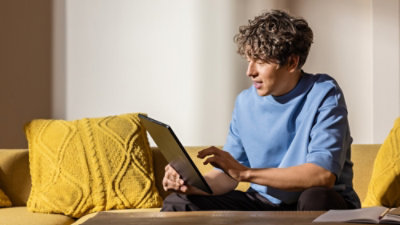 A person sitting on a couch using a laptop.