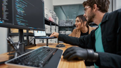 A man and a woman looking at a computer screen.