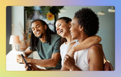 Three friends laughing and looking at a smartphone together in a modern café.