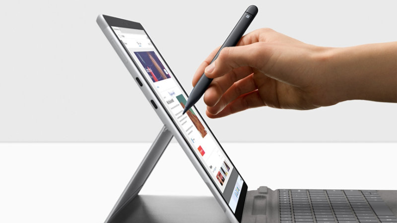 A person uses the Surface Pen 2 on a Surface Pro X with the kickstand open.