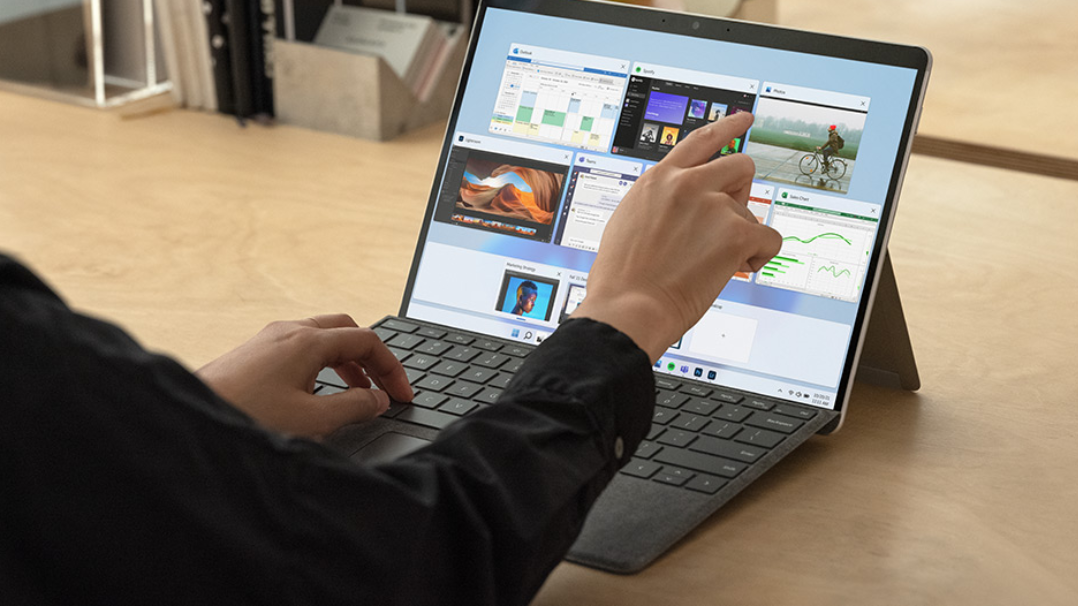 Person tapping the screen of Surface Pro X.