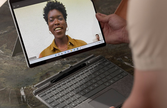 A person connecting Surface Pro X to Surface Keyboard.