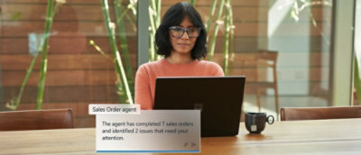 A person wearing a glass sits in front of a computer screen