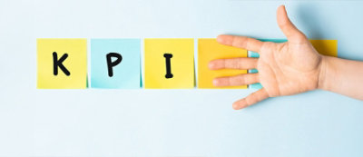 פתקים נדבקים מאייתים "KPI" ולאחריהם יד פתוחה נגד רקע כחול בהיר.