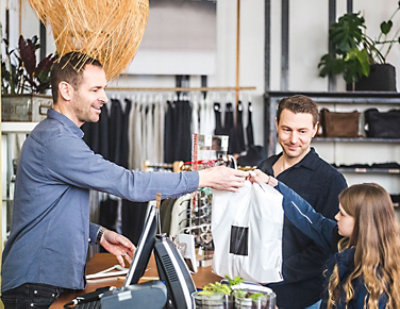 A man giving a bag to a man and a girl.