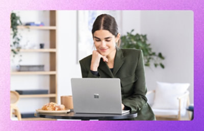 Professional working on a laptop at a small table with coffee.