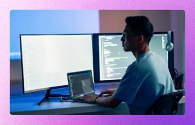 Developer working at a desk with multiple code screens.
