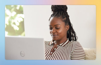 A woman sitting on a couch using a laptop.