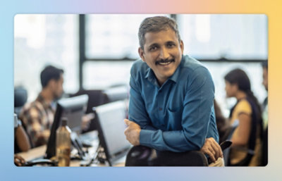 A man with a mustache sitting at a desk.