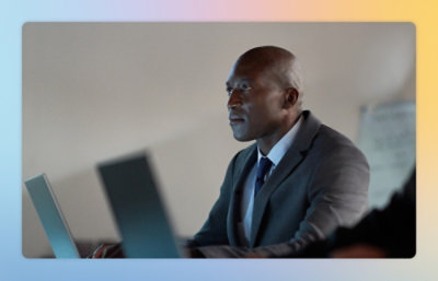 A man in a black suit using a laptop.
