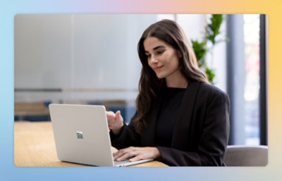 A women wearing black suit working on a laptop