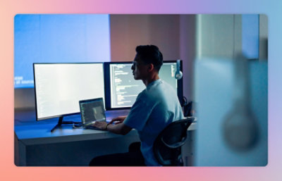A man sitting at a desk using a laptop.