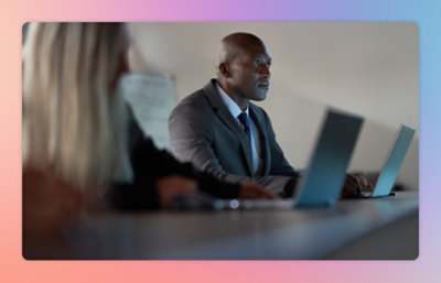 A man in a suit looking at a laptop.