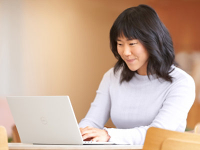 A woman sitting at a table using a laptop.