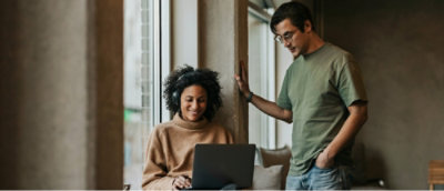 A man and woman discussing while looking at the laptop