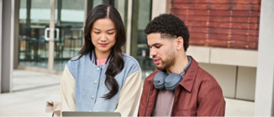 A woman and man discussing while looking at the laptop