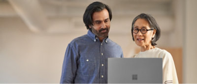 A man and woman looking at the laptop and discussing